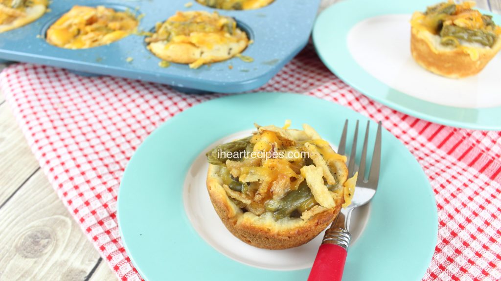 Two blue and white plates with Green Bean Casserole Biscuit Cups set on a red and white tablecloth.