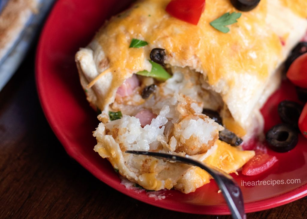 These creamy breakfast enchiladas have tatter tots, onions, olives and tomatoes