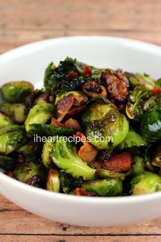 Tender roasted Brussels Sprouts with Balsamic Vinegar & Bacon piled high in a white bowl. This is a perfect side dish for family dinners