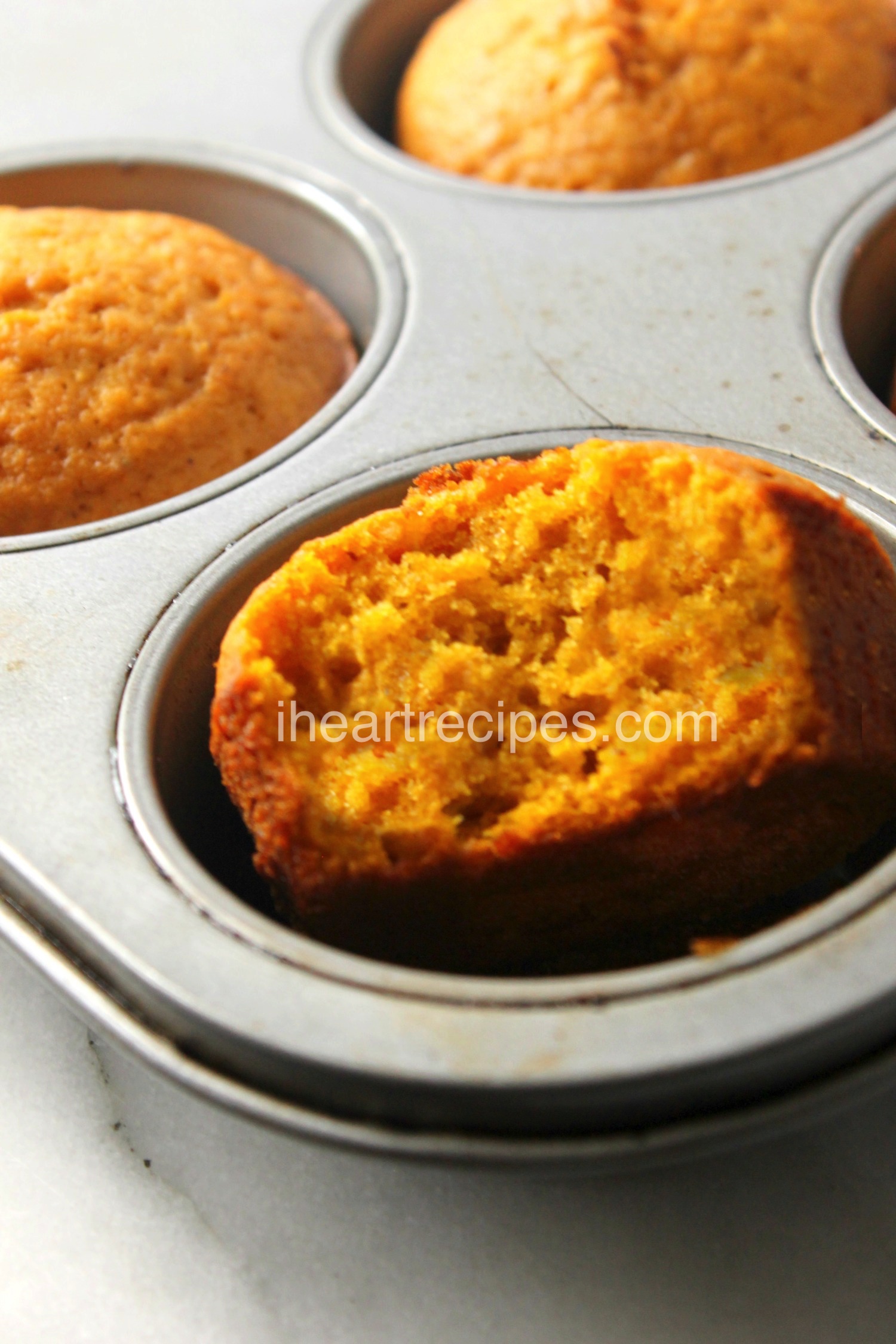 A close-up shot of sweet potato muffins in a muffin tin. These light and fluffy sweet potato muffins are naturally sweet and super moist.