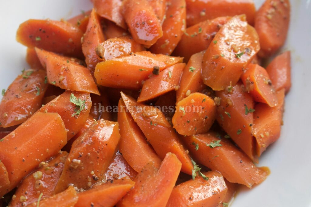 Sliced and seasoned maple-glazed chai carrots served in a classic white serving dish. 