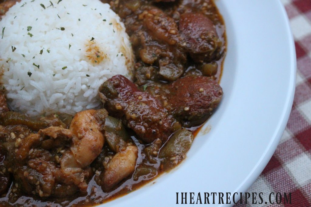 Smothered Okra with Chicken and Sausage alongside tender white rice served in a classic white bowl.