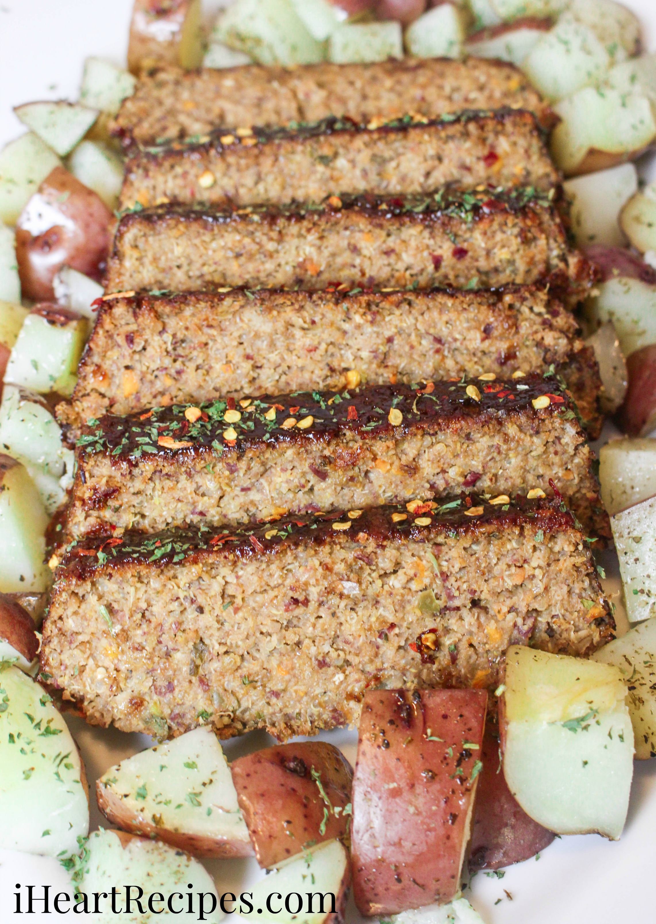 Perfectly seasoned vegetarian meatloaf served alongside fork-tender red potatoes on a white serving platter. This dish is so flavorful and filling!