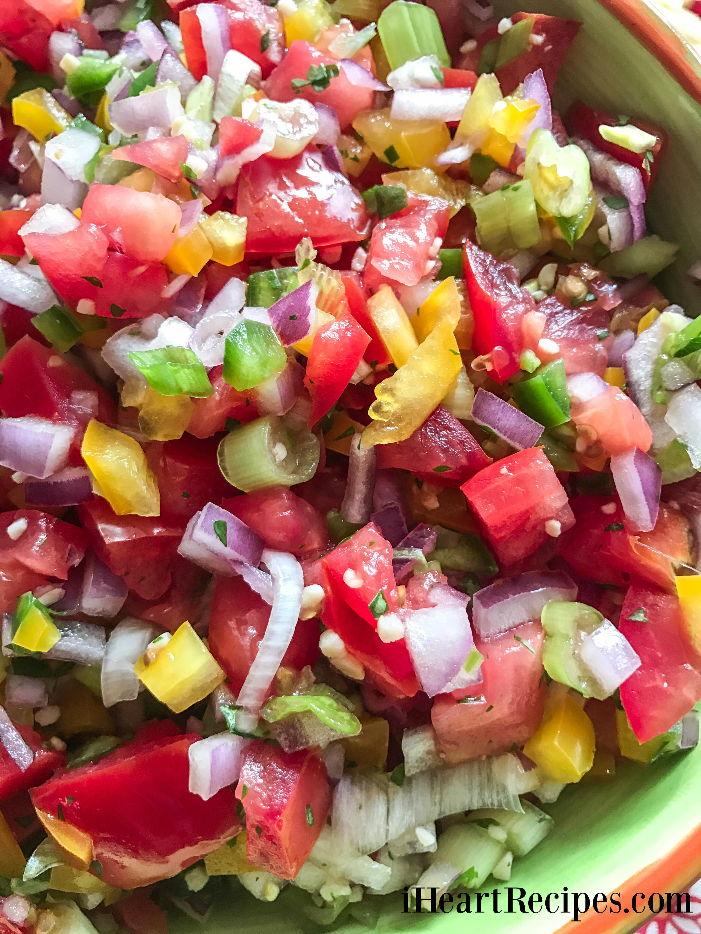 Bright and colorful pico de gallo served in a green ceramic bowl.