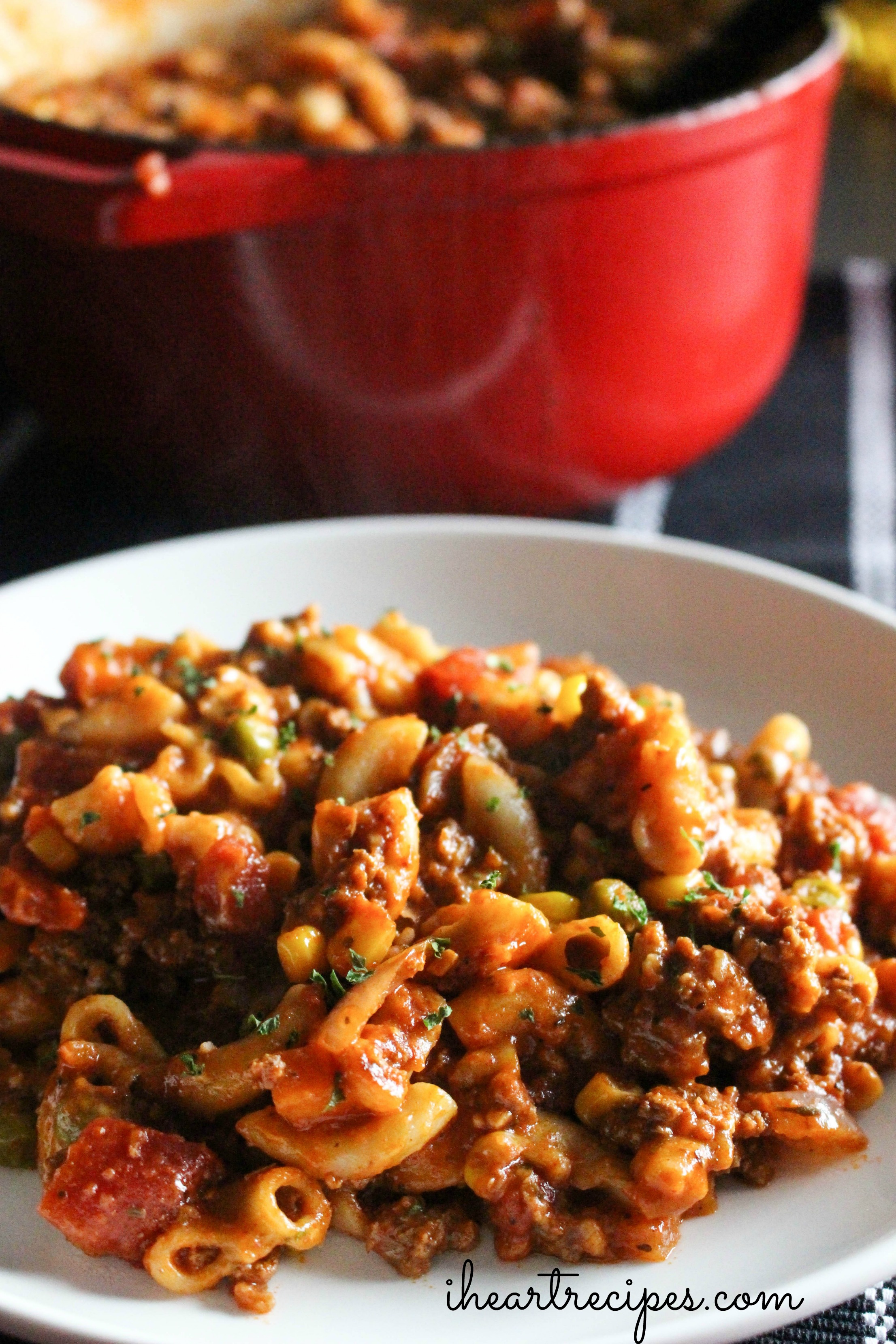 Savory old fashioned beef goulash sprinkled with herbs on a white plate. The perfect comfort meal!  