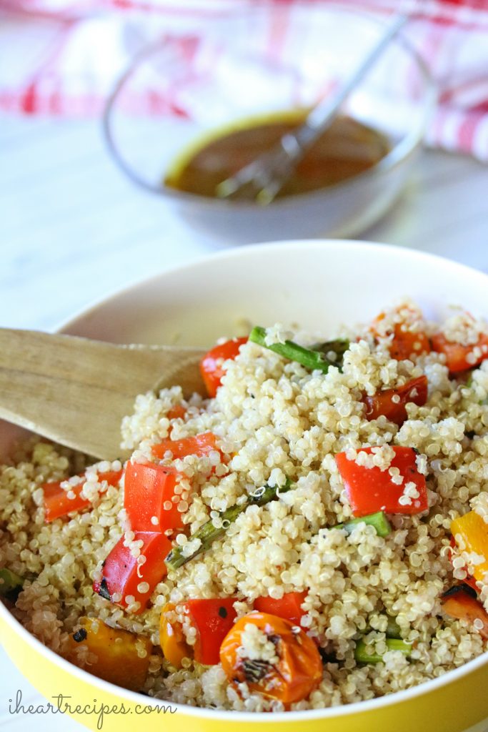 Tasty Easy Quinoa Salad in a yellow bowl served with a rustic wooden spoon. This dish is packed with flavor!