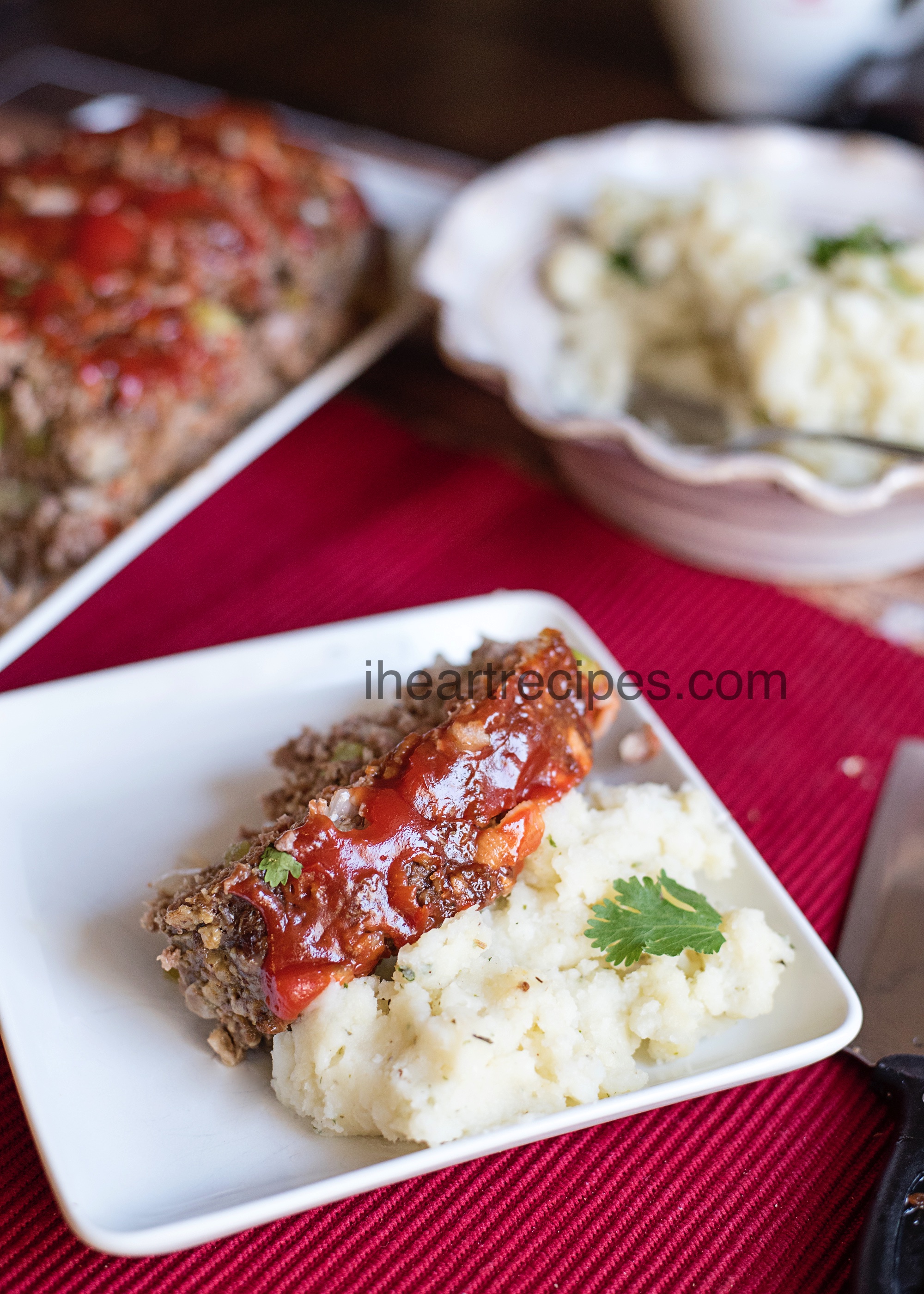 A slice of classic meatloaf served on a bed of creamy mashed potatoes.