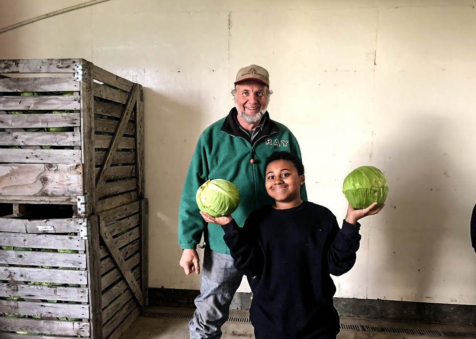 Gio and Mr. Ray show off the impressive cabbages at our local farm.