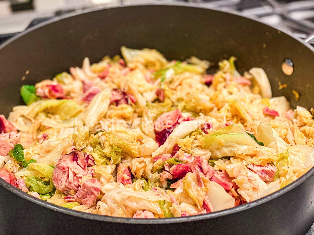 A large pot filled with smothered cabbage and smoked turkey. The cabbage is cooked until tender in a flavorful turkey broth and seasoned with Cajun spices.