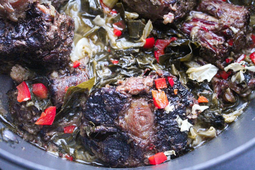 Smoked oxtails served over a bed of perfectly seasoned collard greens