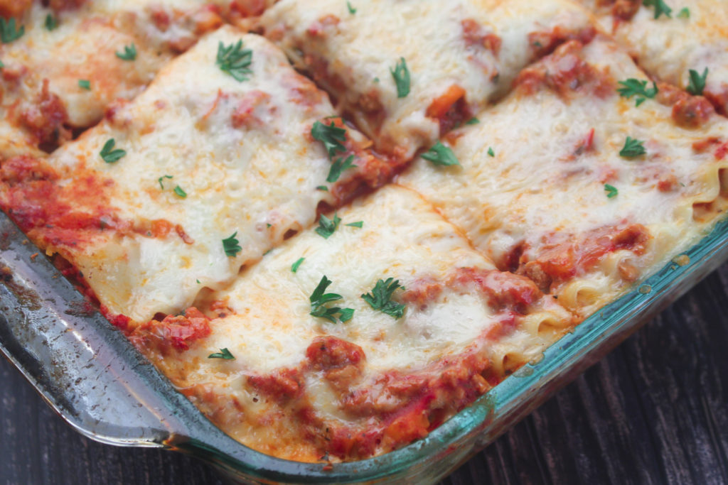 A delicious pan of turkey lasagna topped with sprinkles of parsley flakes