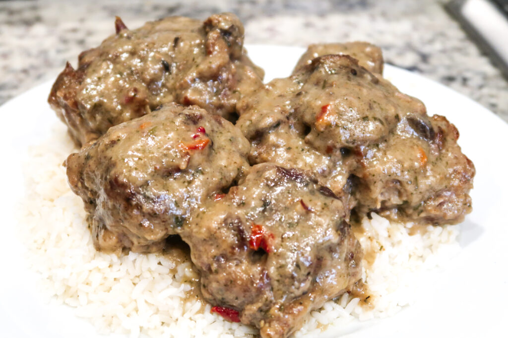 Deliciously slow baked smothered oxtails are covered in a rich, perfectly seasoned gravy.