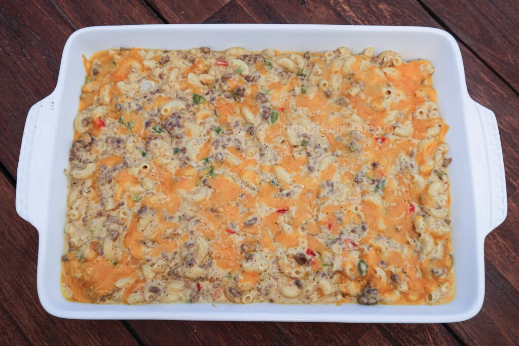 A casserole dish full of homemade  Cheeseburger Hamburger Helper, packed with creamy cheese, macaroni pasta, ground beef, and peppers and onions.