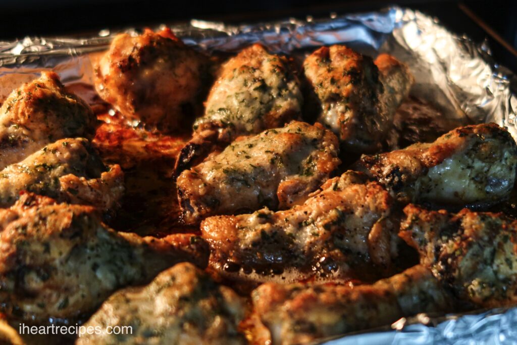 A shot of my homemade garlic parmesan chicken wings baking on a sheet in the oven.