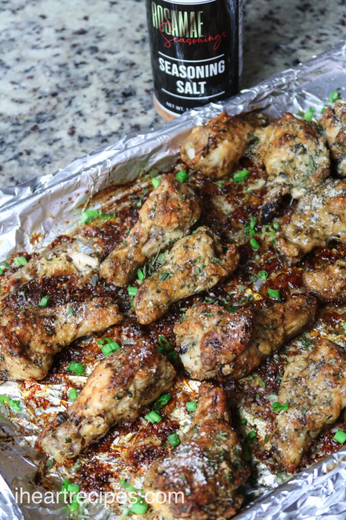 A pan full of my garlic parmesan chicken wings and a bottle of my Rosa Mae seasoning salt - a key ingredient in this recipe.