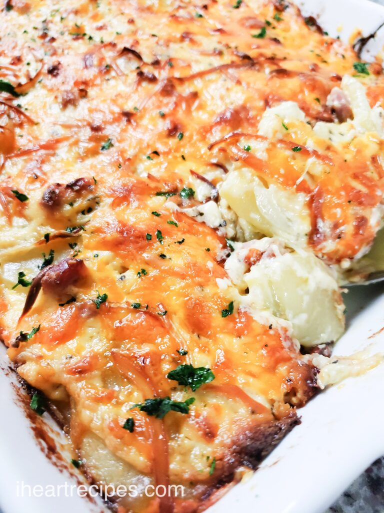 A close up of a spoonful of creamy and tender homemade Scalloped potatoes. 