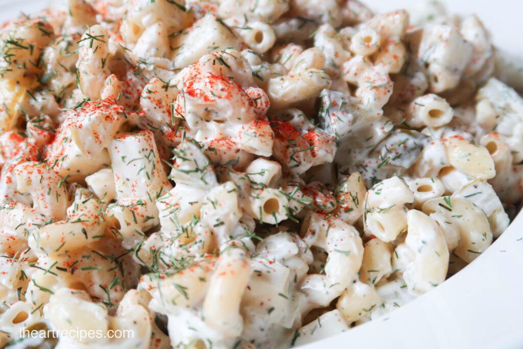 A close up look at my creamy ranch and dill pasta salad, made with macaroni pasta, cheese, and tons of dill and delicious spices.