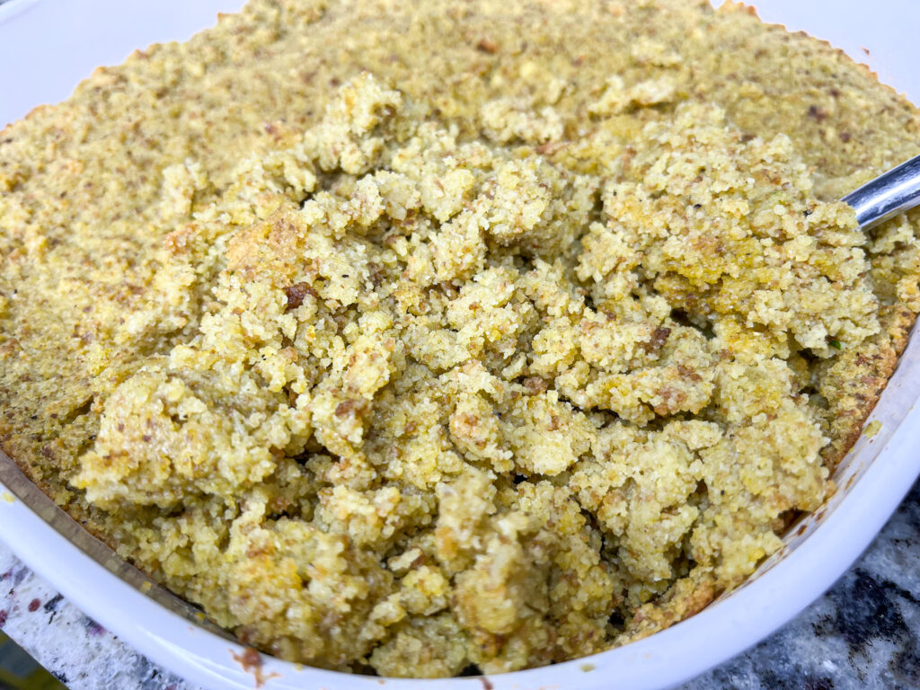 A large white casserole dish filled with homemade cornbread dressing, seasoned with Rosamae Dressing Seasoning.