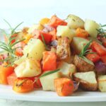 Air fryer roasted potatoes, squash, onions, and sweet potatoes with fresh herbs.