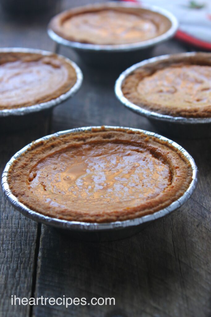 Four mini pumpkin pies with a butter pie crust and sweet pumpkin filling, perfect for parties and holidays.