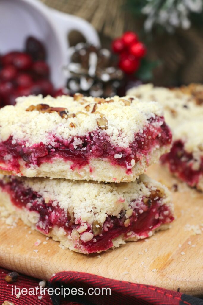 Two yummy cranberry pecan bars - a shortbread base filled with tart cranberries and topped with a crunchy pecan topping.