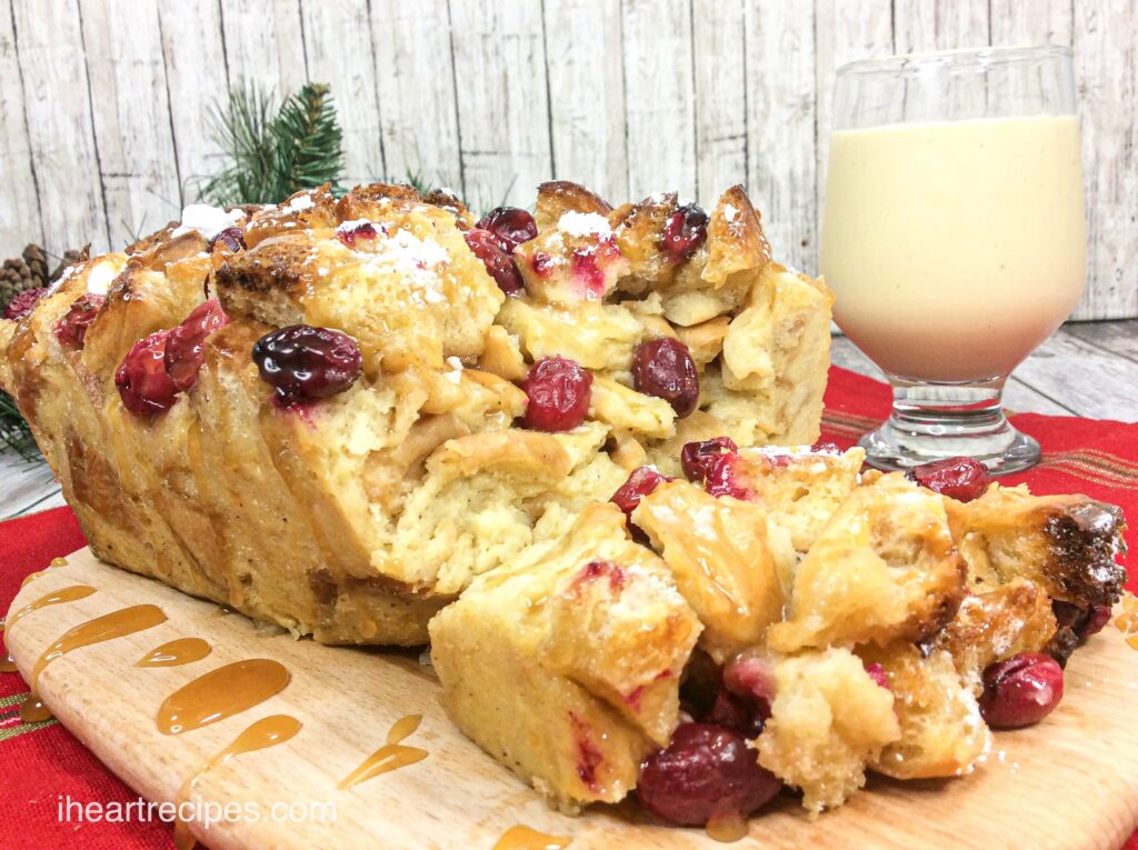 A loaf of eggnog bread pudding, filled with cranberries and drizzled with a homemade whiskey sauce. Enjoy this holiday treat with a glass of cold, creamy eggnog.