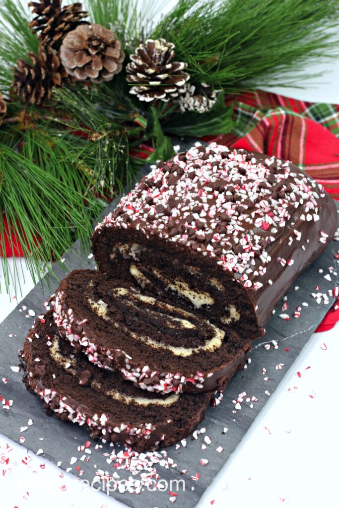 A gorgeous chocolate Swiss roll cake, filled with a creamy peppermint buttercream and covered with a homemade chocolate peppermint ganache and crushed candy canes.