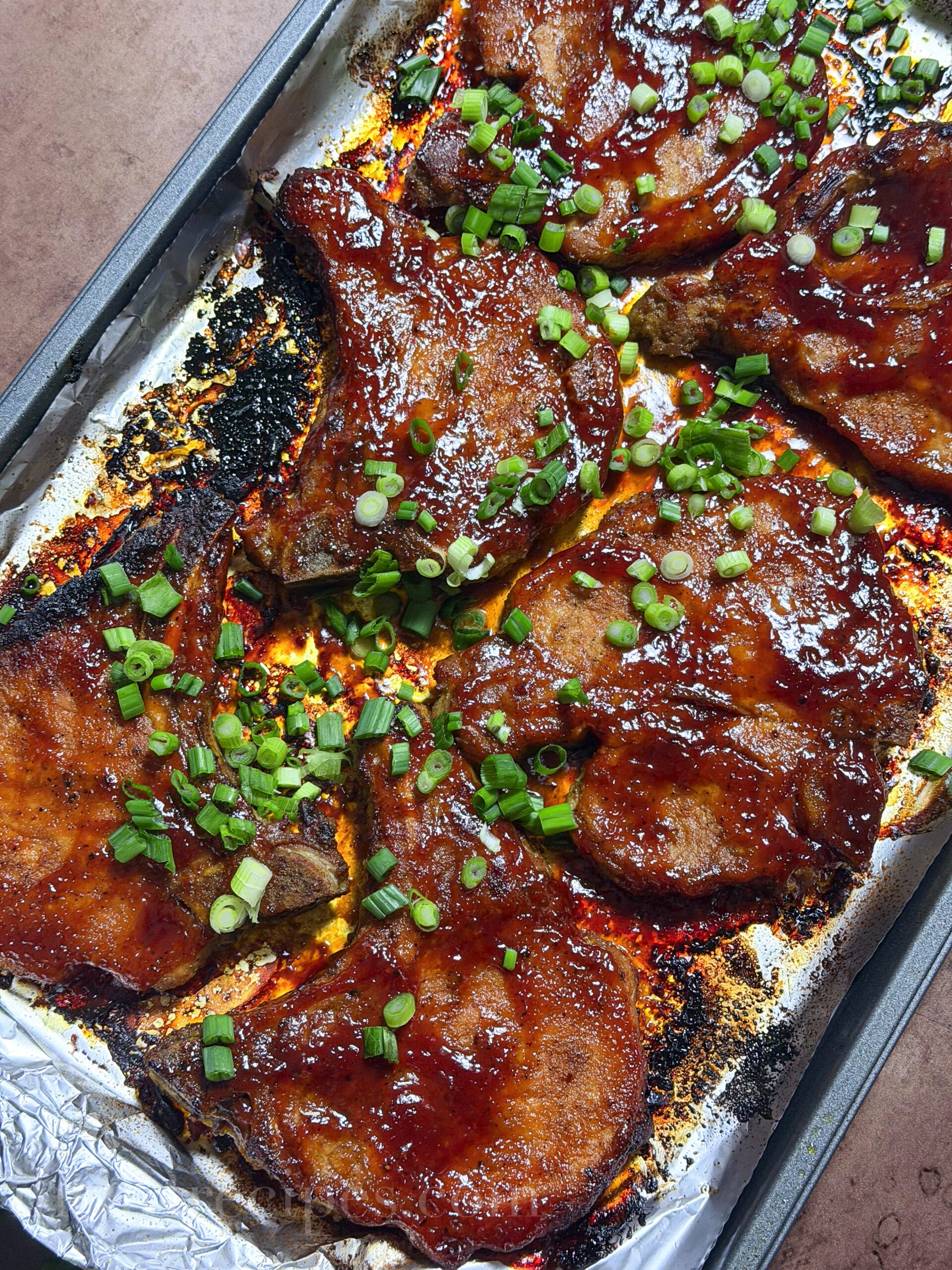 Over head of baecue pork chops on a baking sheet.