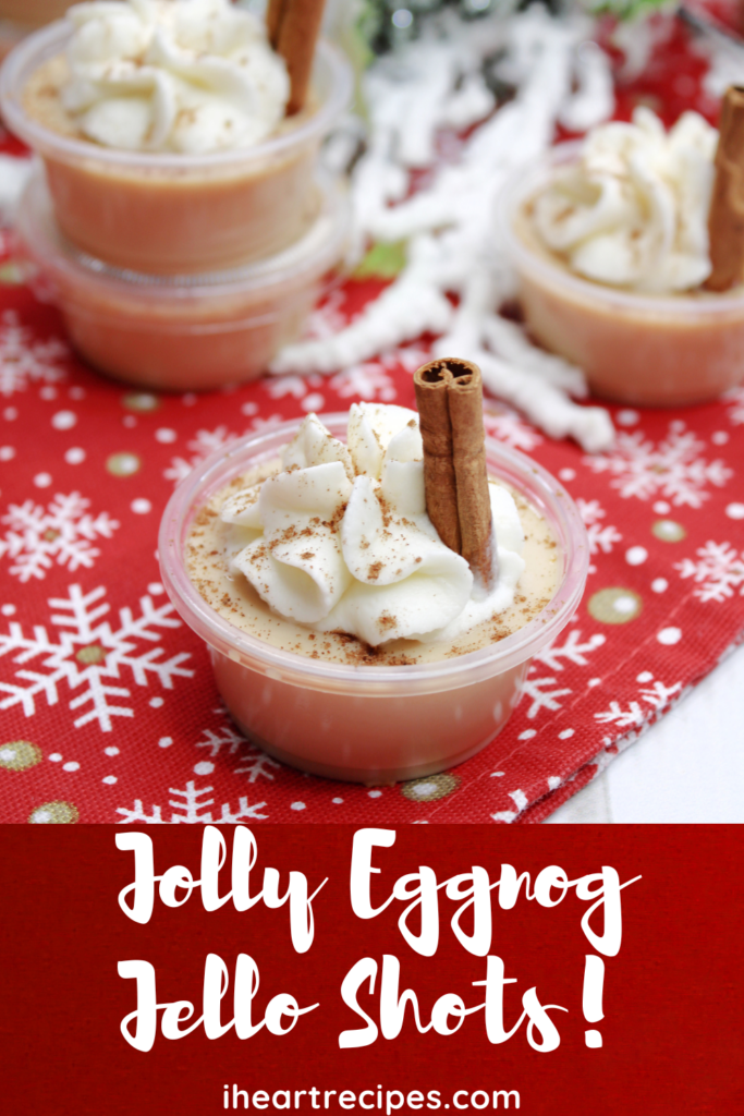 Small cups of eggnog jello shots, topped with cinnamon and whipped cream. Image overlay text reads "jolly eggnog jello shots"