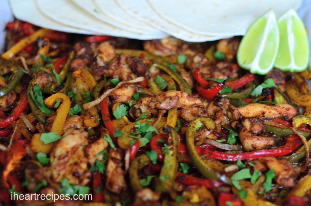 Sheet Pan Chicken Fajitas made with strips of chicken, peppers, onions, and a zesty seasoning mix.