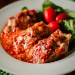 Italian baked stuffed shells served in a bowl with a salad.