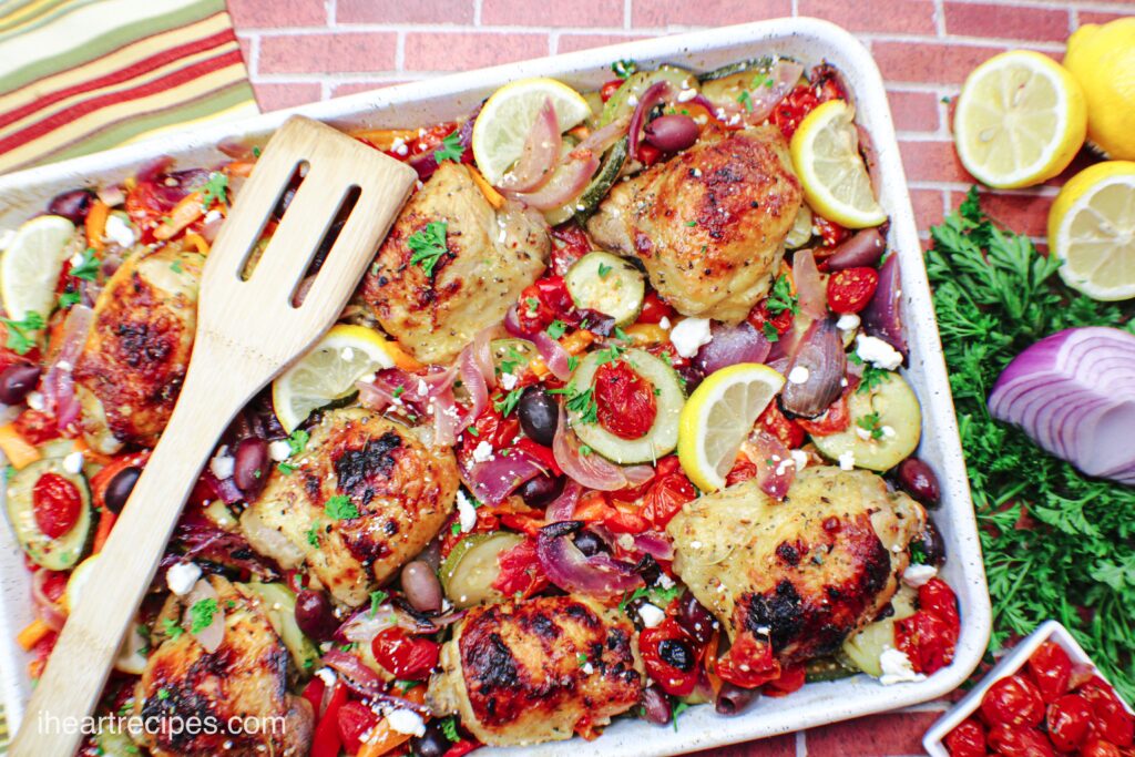 A sheet pan chicken dinner that's seasoned to perfection and baked with cucumbers, tomatoes, onions, olives, and topped with Feta cheese for a combination of Greek flavors.
