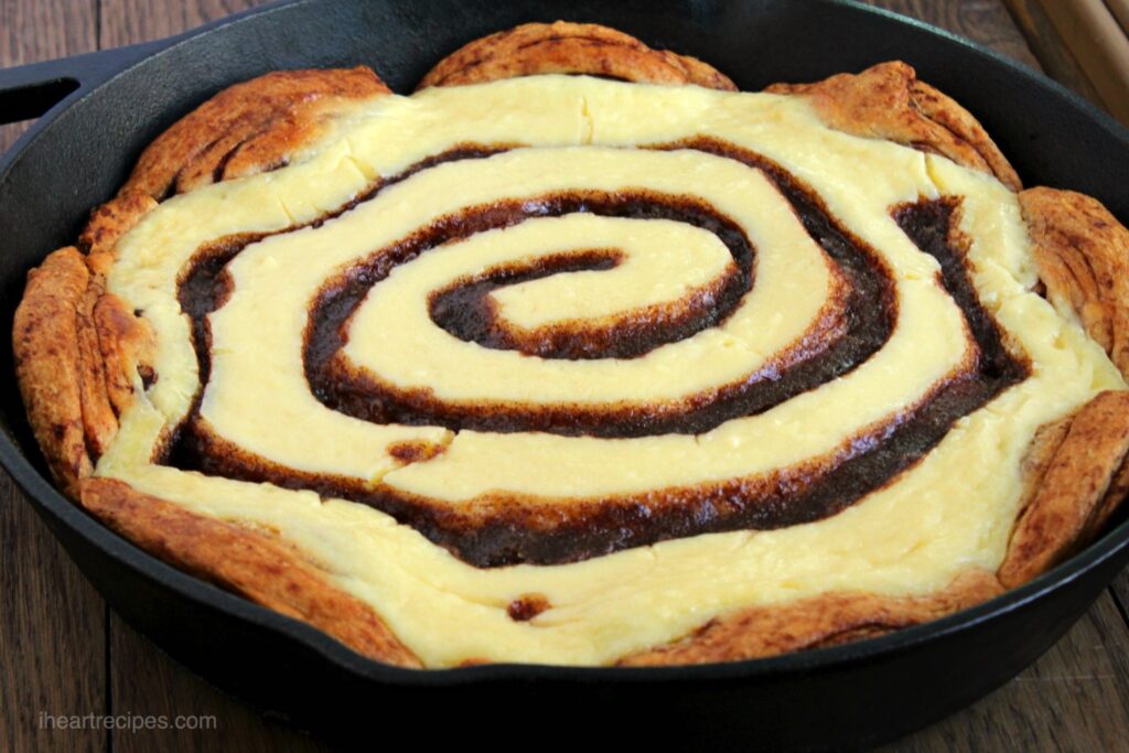 A cinnamon roll cheesecake made with store-bought cinnamon roll crust and a cinnamon and cream cheese swirl filling.