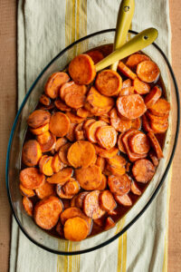 Baked candied yams in an oval glass baking dish.