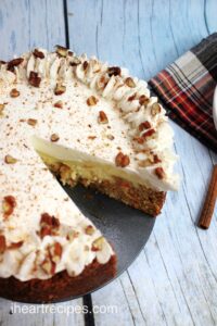 Carrot cake cheesecake with a single slice cut out.