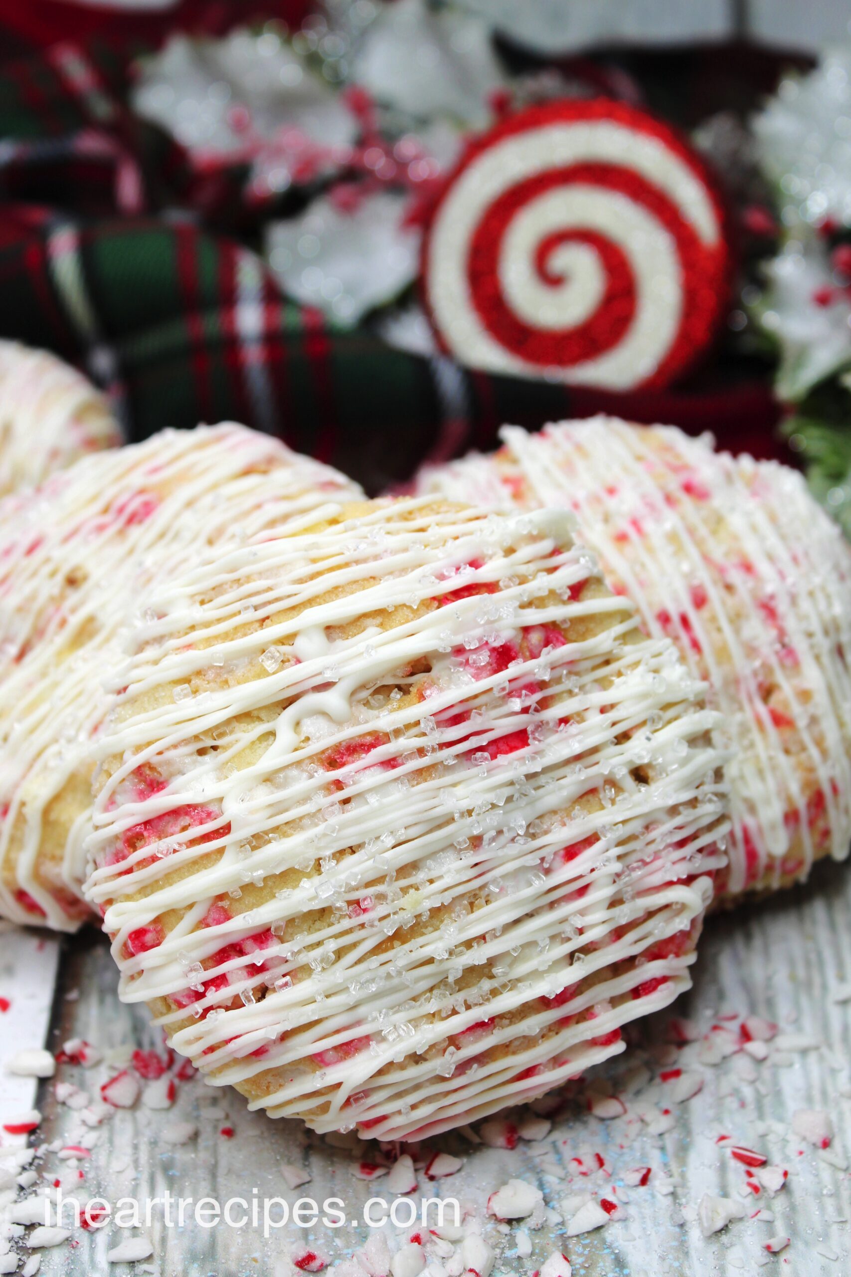 A closeup image of peppermint cheesecake cookies, drizzled with vanilla frosting and coarse sanding sugar.