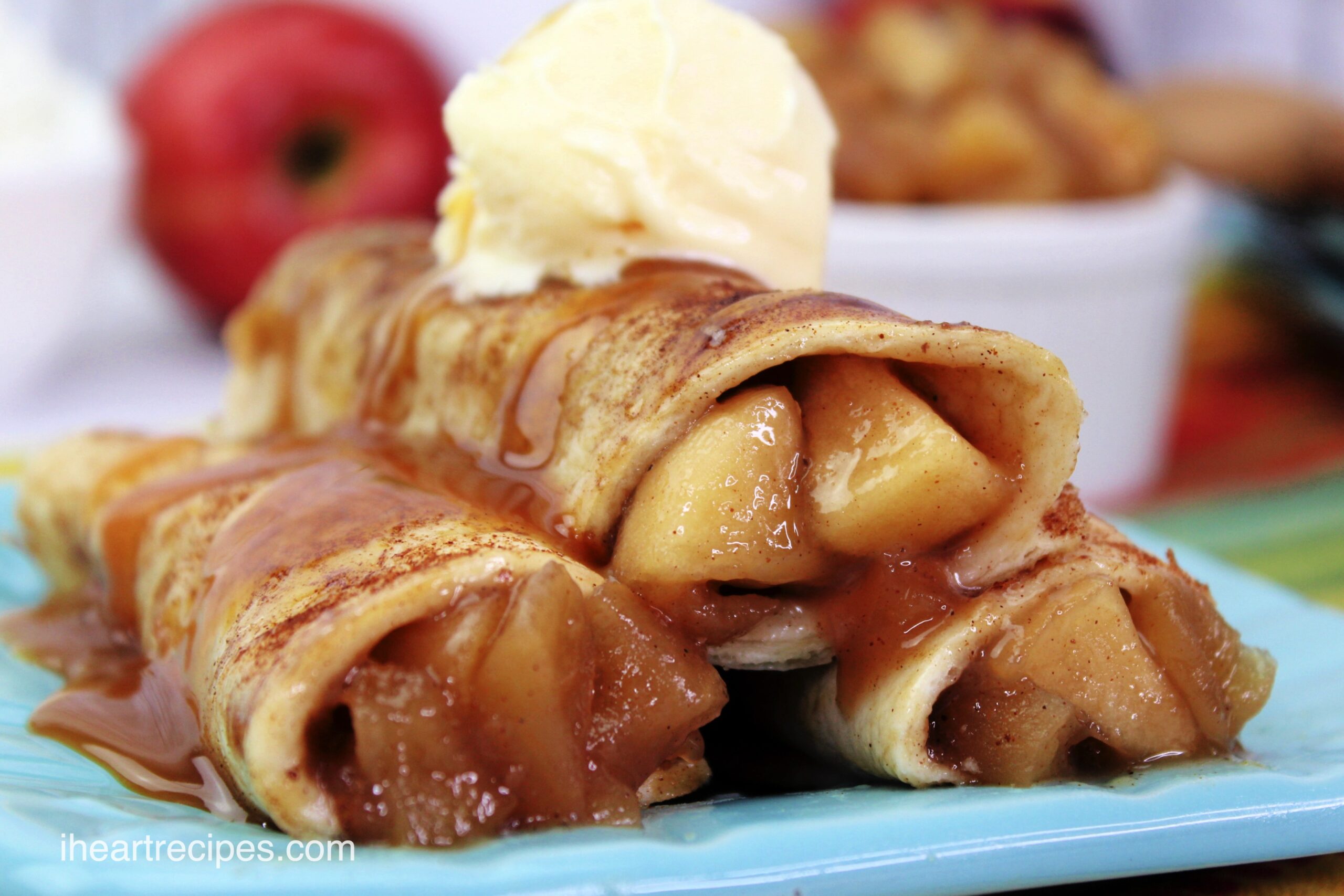 A stack of three Caramel Apple Taquitos - cinnamon sugar tortillas filled with apple pie filling, topped with a scoop of vanilla ice crea,