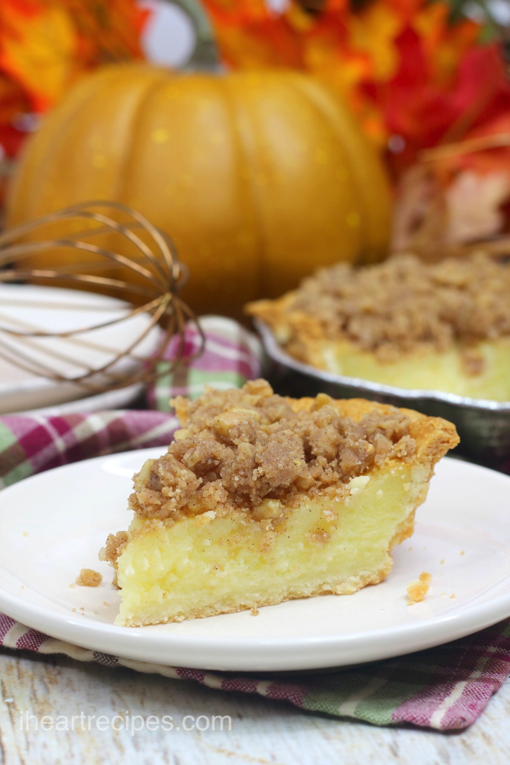 A single slice of streusel buttermilk pie served on a plate. This holiday pie has a creamy buttermilk filling topped with a classic homemade streusel.