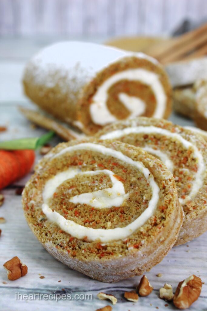 Slices of moist rolled carrot cake stacked in a row.