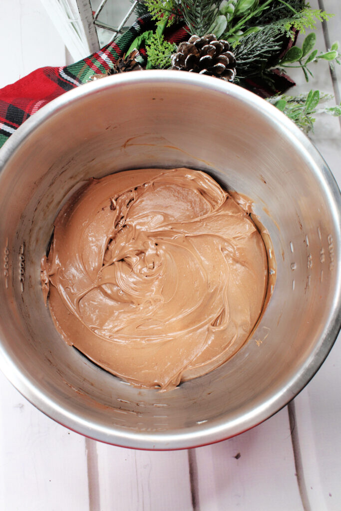 Creamy light brown batter rests in a silver mixing bowl.  