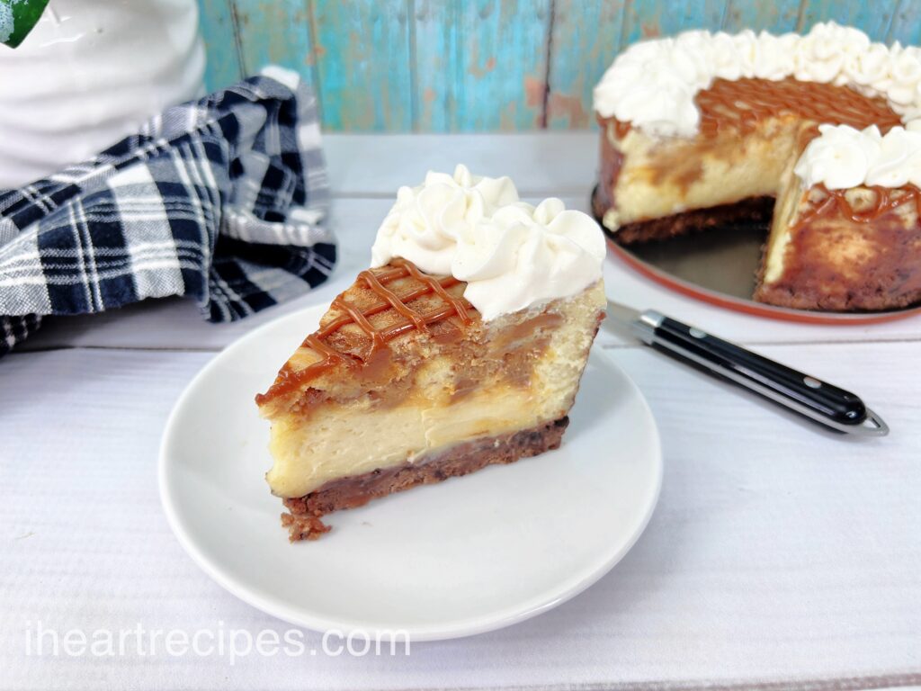 A golden creamy slice of dulce de leche cheesecake on a round white plate. 