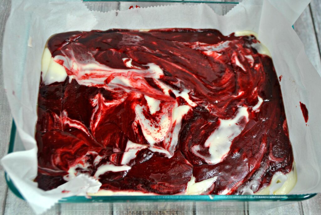Red velvet swirl fudge poured in a parchment paper-lined glass bake dish. 