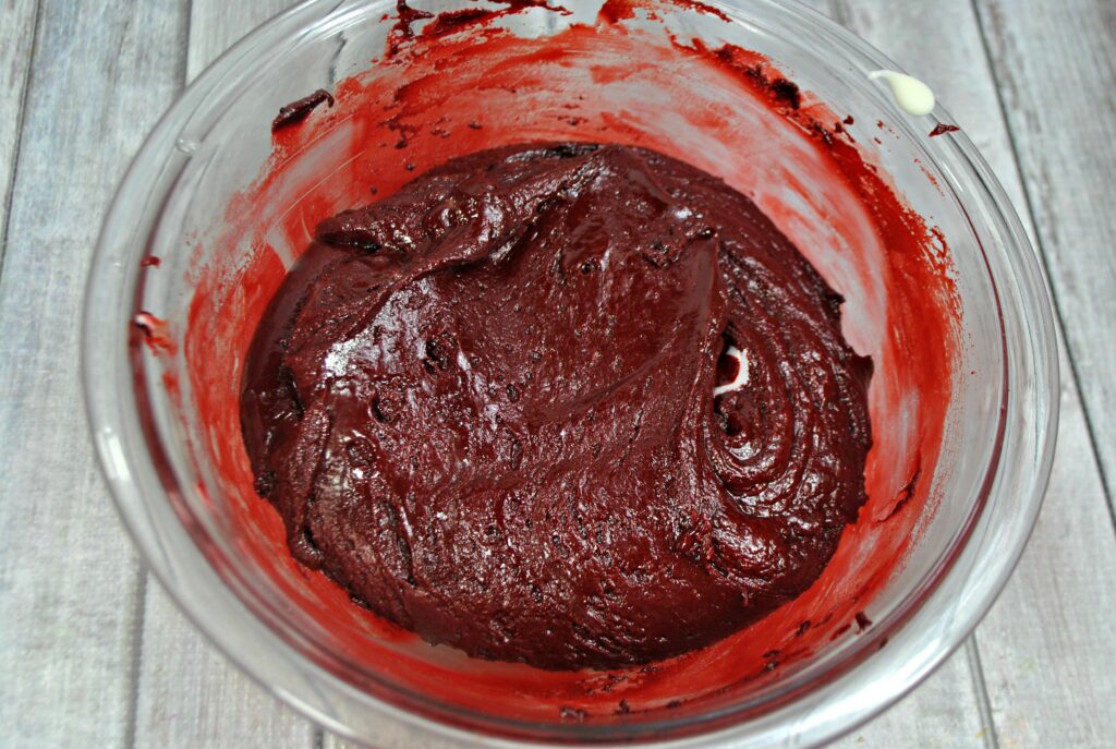 Red velvet batter resting in a glass mixing bowl.