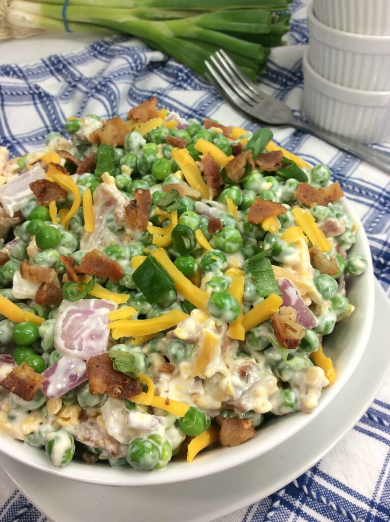 A close up Pea, Bacon and Cheddar Salad showcasing the varying textures and colors.