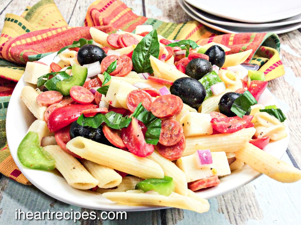 Tender pasta, savory pepperoni and olives, creamy cheese and crisp veggies are tossed together in a white pasta bowl.   