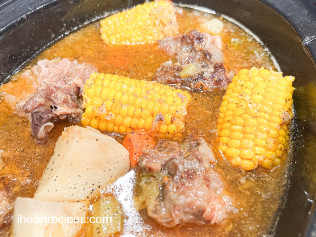 Soul Food Style Pork Neck Bone Soup simmering in a black Crockpot. 