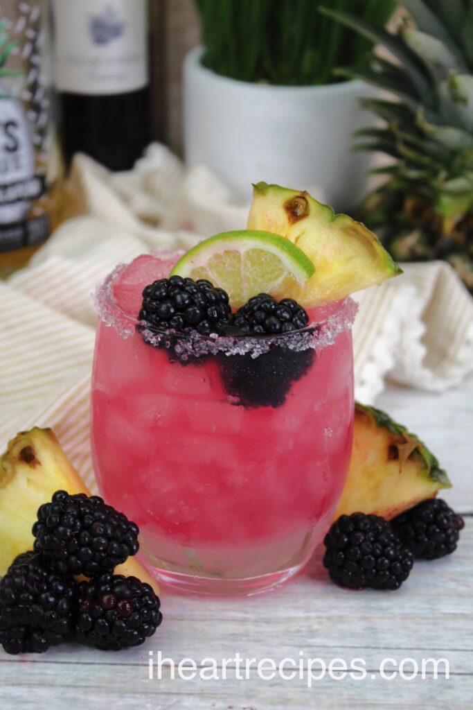 A clear glass rimmed with salt filled with Fruity Blackberry Margaritas.