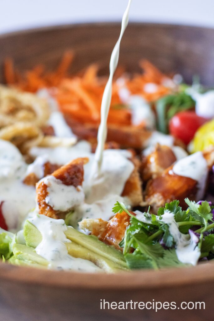 Creamy ranch dressing is drizzled on a BBQ Chicken Salad. 