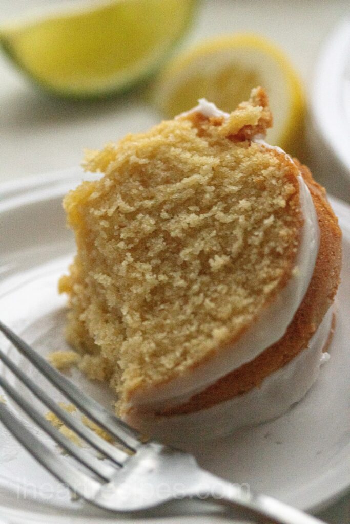 A dessert  served on a plate with icing with a fork.