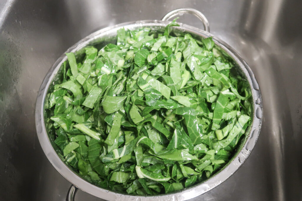 fresh collard greens sliced up and in a colander.